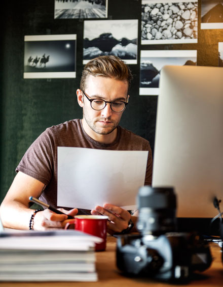 Mann arbeitet am Schreibtisch und prüft Unterlagen für Gastbeitragsdienste Deutschland