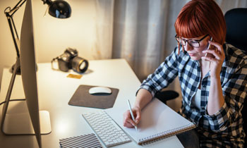 Frau arbeitet am Schreibtisch und erstellt Inhalte für Gastbeitragsdienste Deutschland